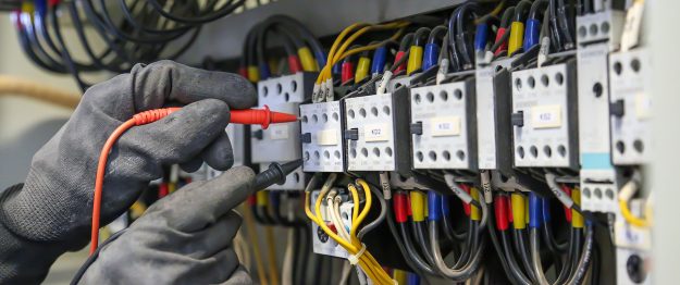 Electrical engineer using digital multi-meter measuring equipmen Electrical Service