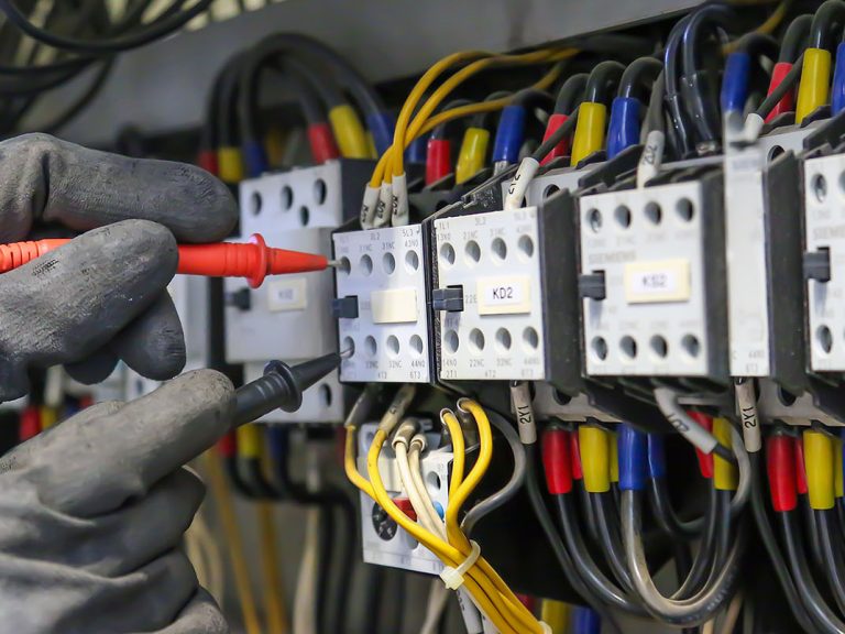 Electrical engineer using digital multi-meter measuring equipmen Electrical Service